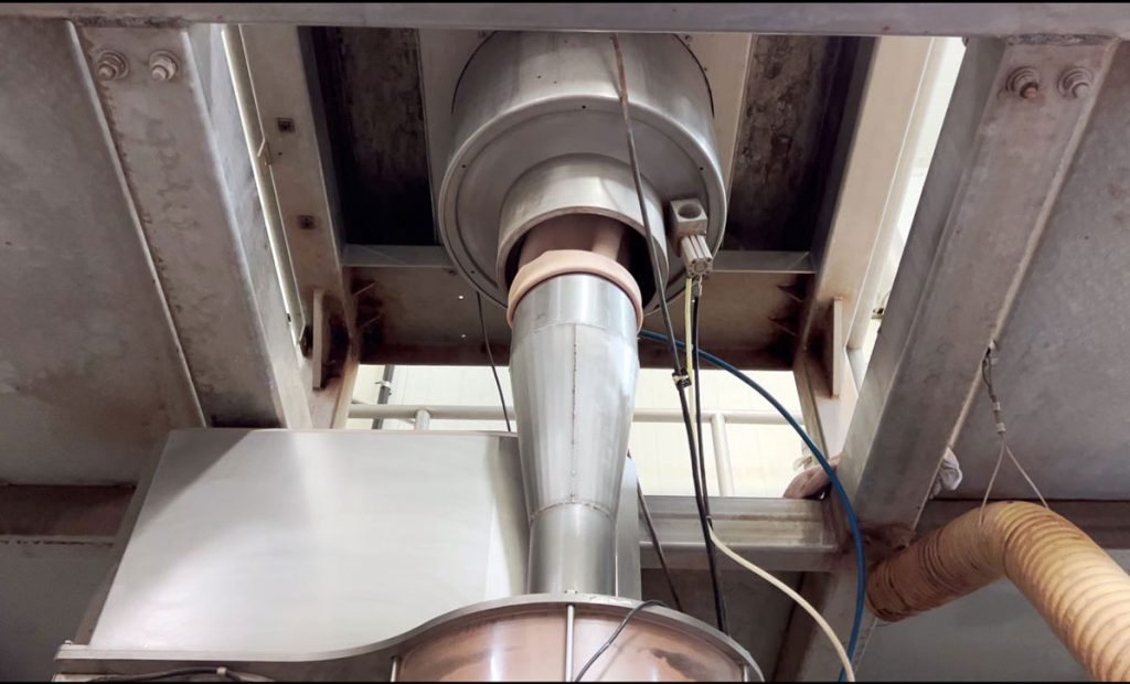Bottom view of IBC container discharge station and connection to vertical auger filling machine
