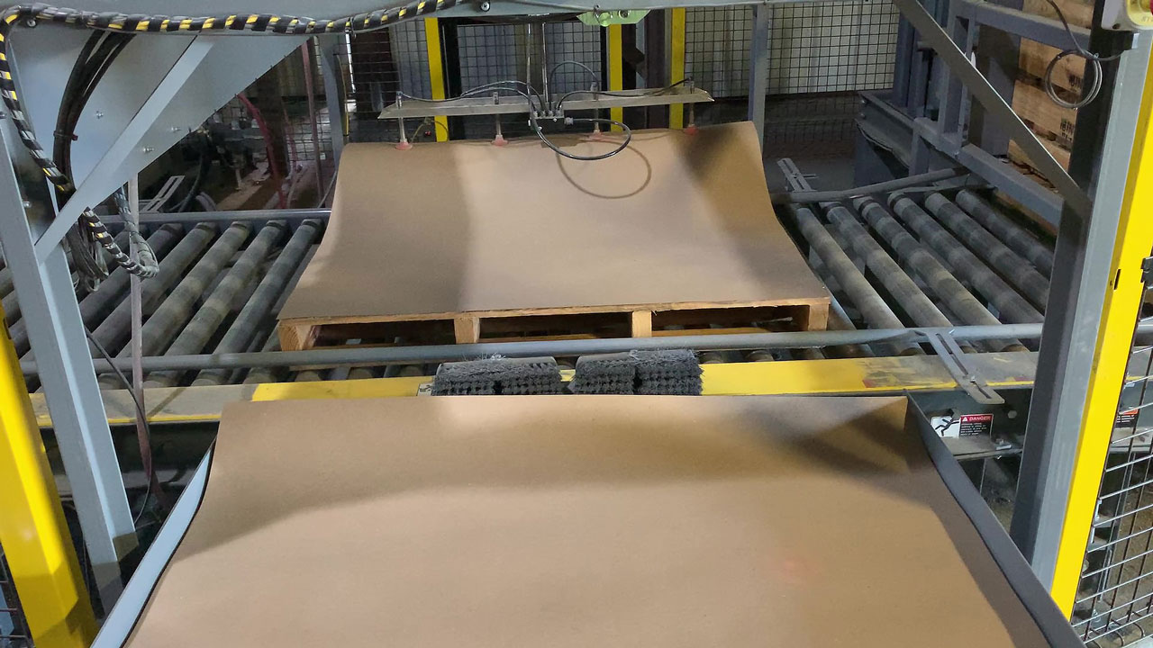 Automatic slip sheet dispenser placing slip sheet on a pallet