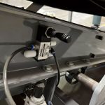 bag flattener conveyor uses compressed air to adjust the opening between top and bottom belts