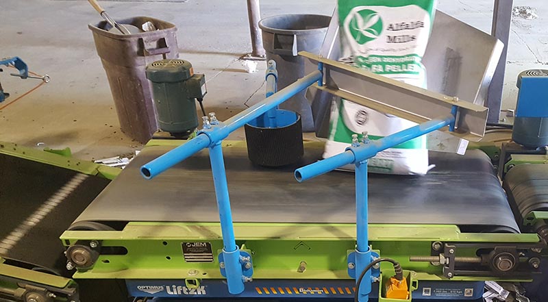 bag turner conveyor knocks down bags of alfalfa pellets