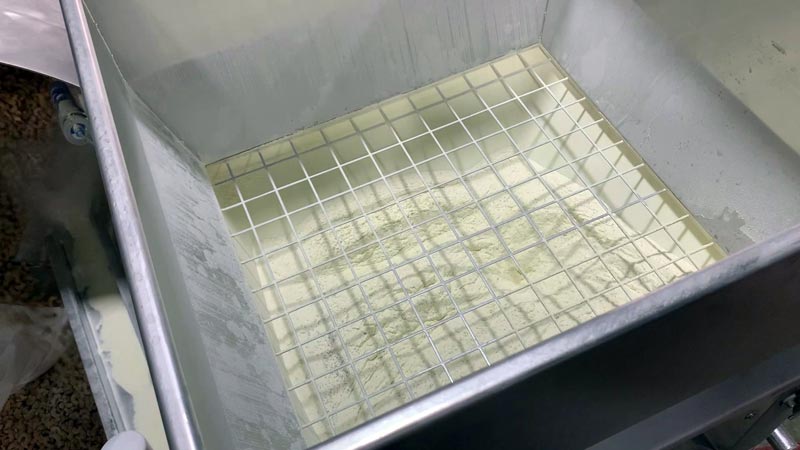 walls of lower hopper flex and discharge dry seasoning into pan feeder