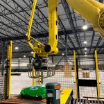 fanuc arm and tool picks up bags of dog food and palletizes them in automatic system