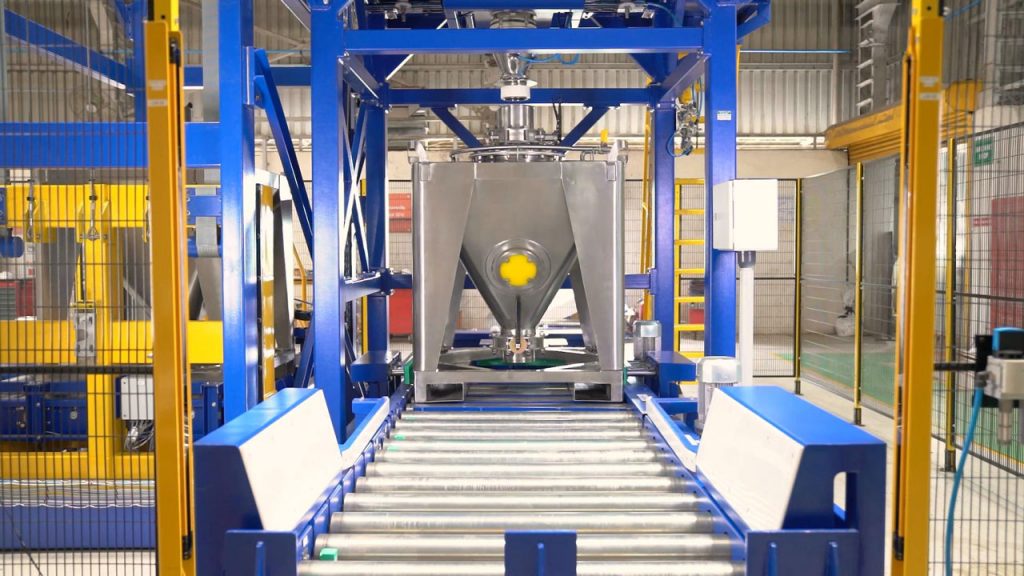 empty IBC is conveyed under filling spout of discharge station