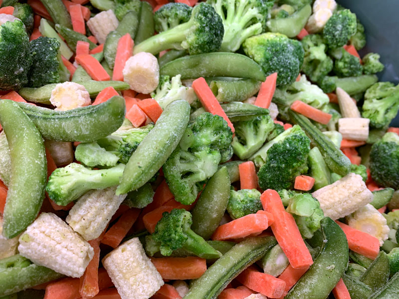 evenly coating frozen vegetables with topical seasoning using electrostatics