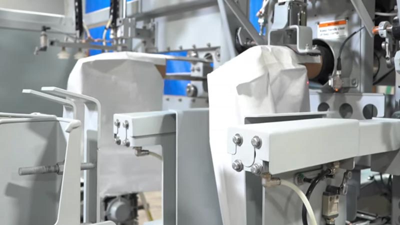 automatic bag placer placing empty bag on filling spout