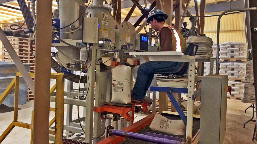 operator placing bags on valve bag filling machines