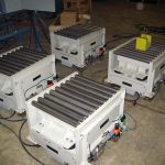 vibratory compaction using grid deck vibratory table under roller conveyors