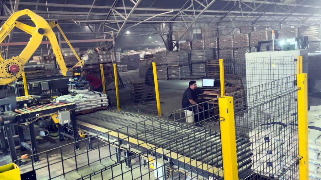 robotic bag palletizer stacking bags on left bagging line