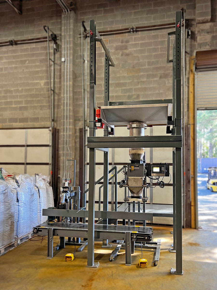 bulk bag unloading system repackages water filter media into open mouth bags