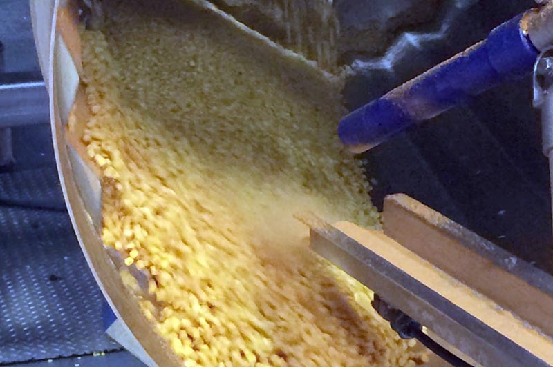 Seasoning fresh corn inside a coating drum using an electrostatic wand