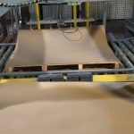 Automatic slip sheet dispenser placing slip sheet on a pallet