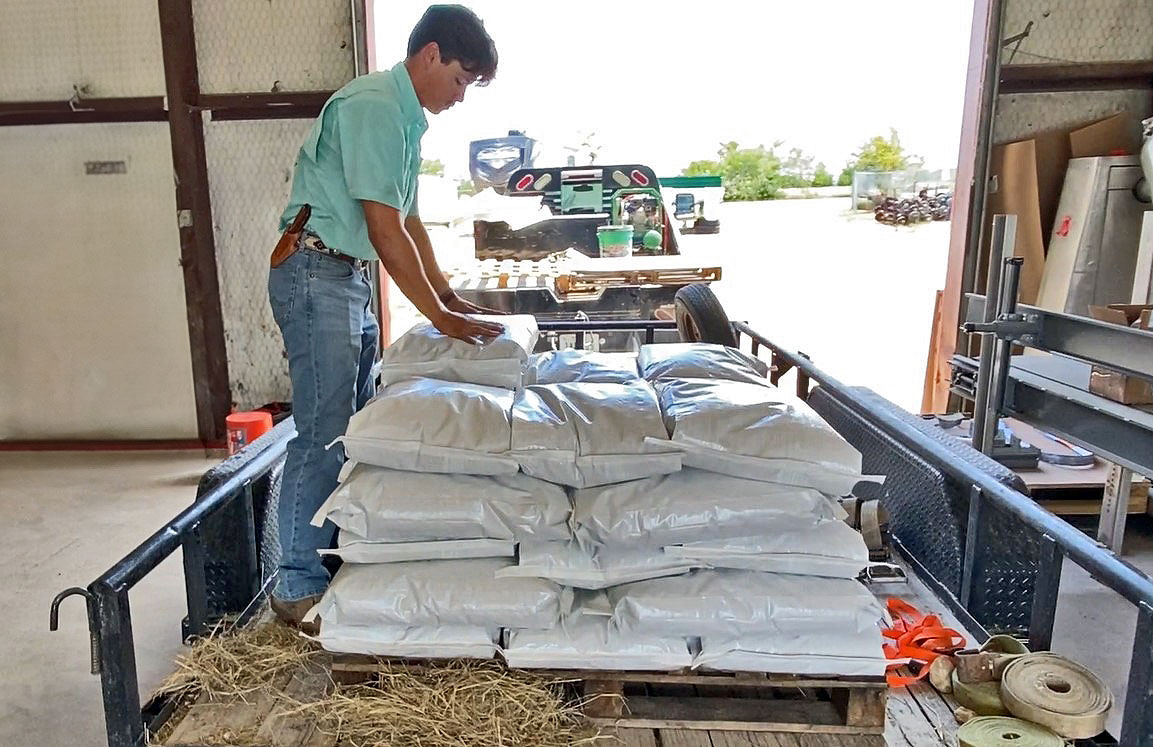 Stacking 25 lb. bags of horse pellets on pallet in truck trailer