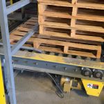 Empty pallet being dispensed from automatic pallet dispenser