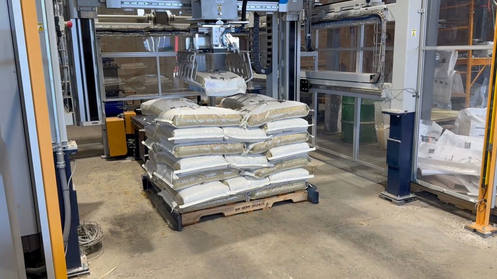 SentryStack Palletizer Stacking Bags of Animal Feed on a Pallet with a Slip Sheet