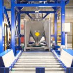 empty IBC is conveyed under filling spout of discharge station