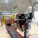 view of entire bagging system including gross weight bagging scale, conveyors, bag flattener, and palletizing robot